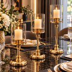Gold glass pillar candle holders displayed on a sophisticated dining table with candles and decorative flowers