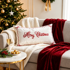 White embroidered Merry Christmas pillow covers styled on a sofa with a Christmas tree and festive decorations.