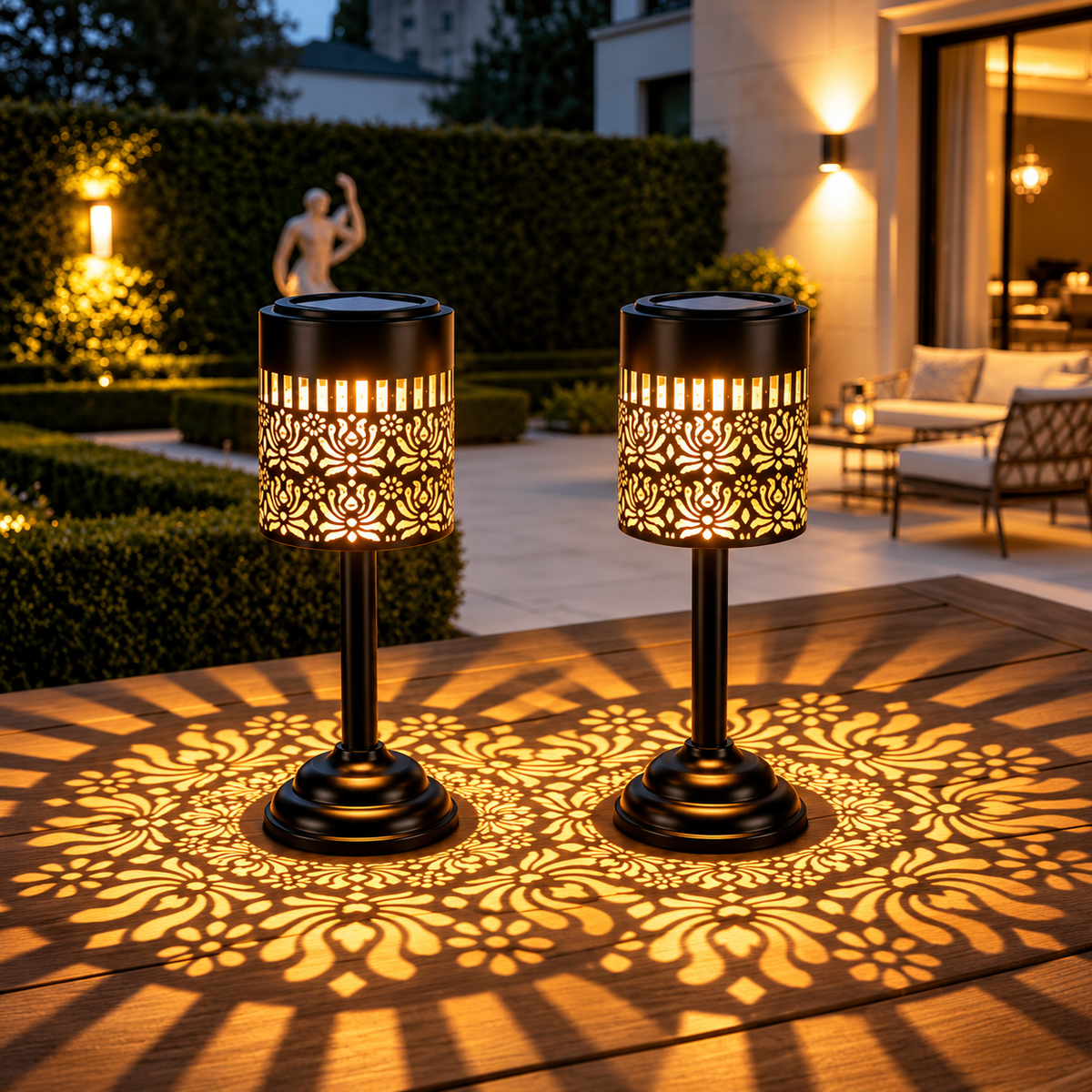 Two solar table lanterns with warm white light and decorative floral patterns on an outdoor patio table