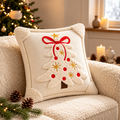 Embroidered Christmas pillow covers featuring a raised white Christmas tree, red bow and gold star on a cream cushion.