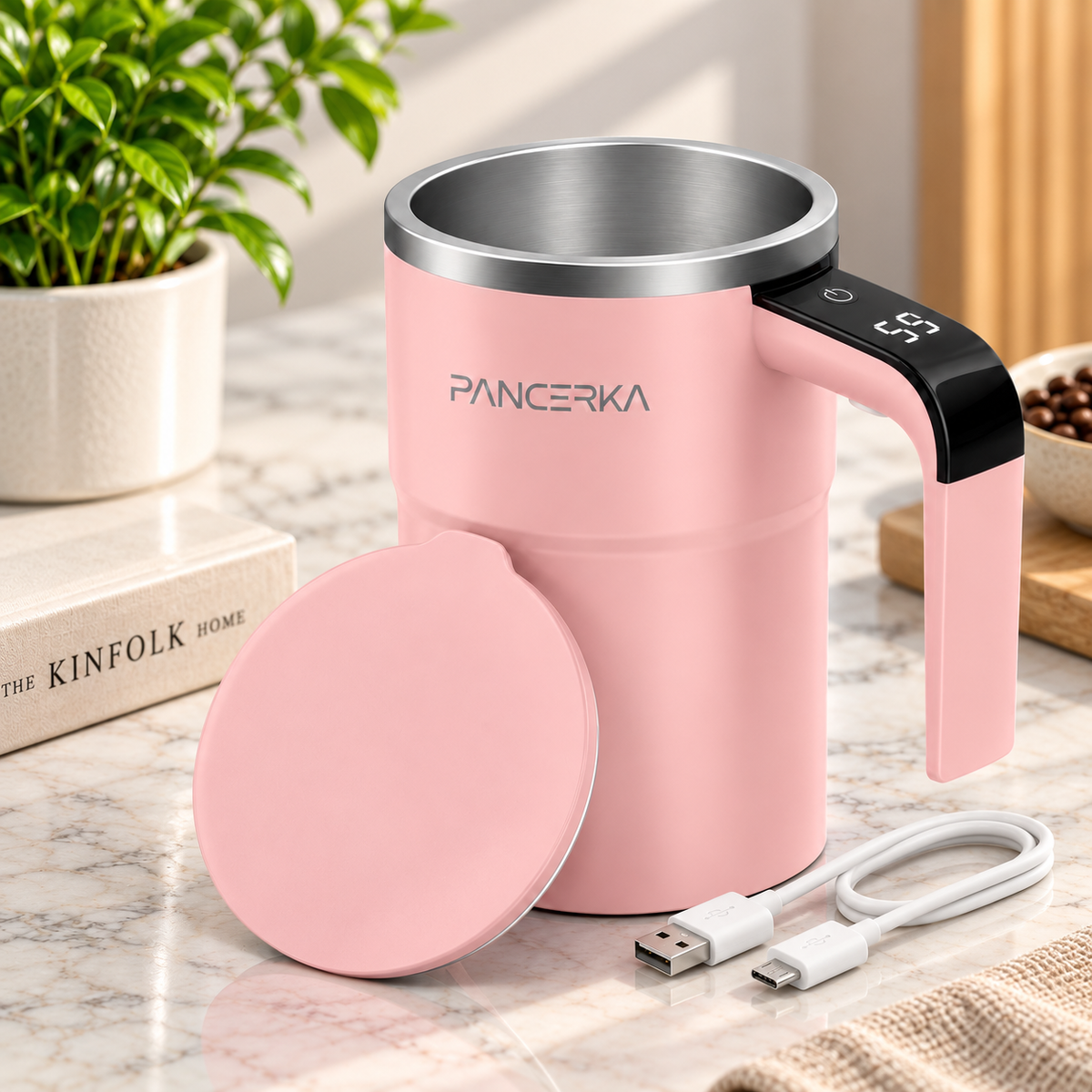 self-stirring coffee mug in pink with matching lid styled in a modern kitchen