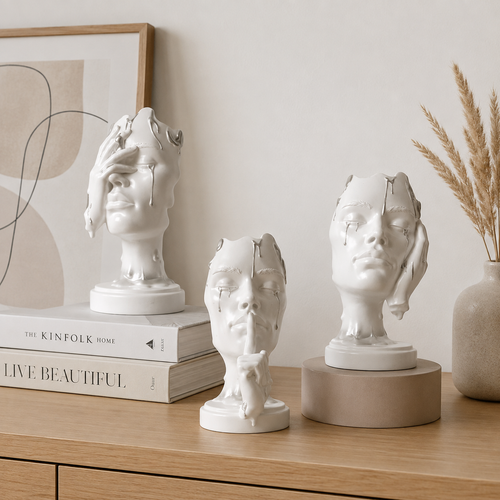     Abstract face sculpture displayed with decorative books and neutral home decor on a console table.