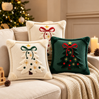 Embroidered Christmas pillow covers in cream with decorative Christmas trees, red bows and gold star details.