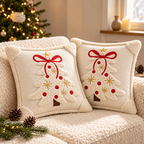Embroidered Christmas pillow covers in cream with decorative Christmas trees, red bows and gold star details.