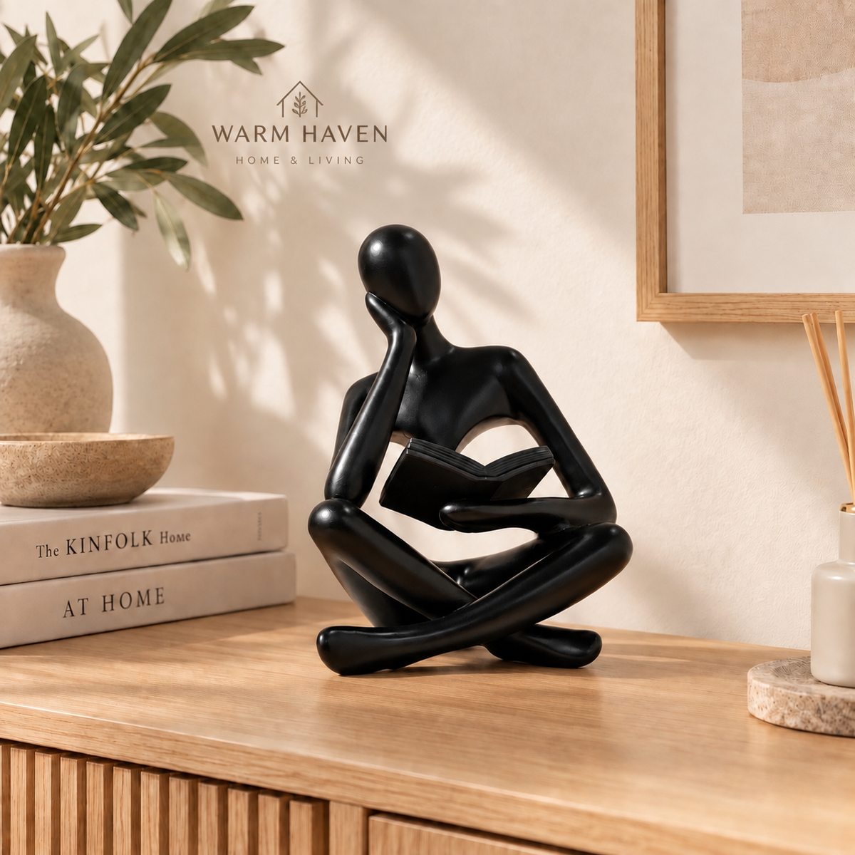 Black abstract thinker sculpture styled on a wooden console with minimalist Scandinavian decor