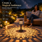 Two solar table lanterns with warm white light and decorative floral patterns on an outdoor patio table