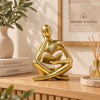 Black abstract thinker sculpture styled on a wooden console with minimalist Scandinavian decor