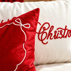 Close-up of red and white embroidered details on a Christmas pillow covers.