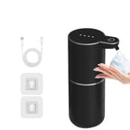 Black soap dispenser with USB cable and wall outlet adapter on a white background